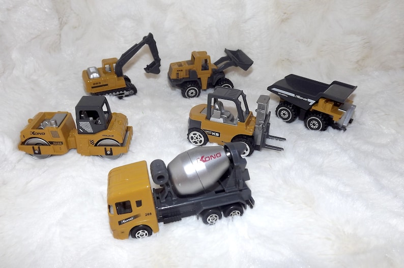 K&ouml;nnte beinhalten: Ein Set aus sechs gelben Spielzeug-Baufahrzeugen, darunter ein Betonmischer, ein Gabelstapler, ein Kipplaster, eine Stra&szlig;enwalze und ein Bagger. Die Fahrzeuge sind alle aus Kunststoff und haben schwarze R&auml;der.
