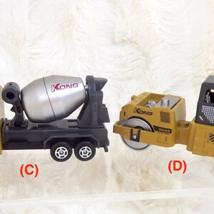K&ouml;nnte beinhalten: Zwei Spielzeug-Baumaschinen, ein gelber Betonmischer-LKW mit einer silbernen Trommel und ein gelber Walzen-LKW mit schwarzen Details. Beide LKWs haben den Schriftzug "KONG" aufgedruckt.