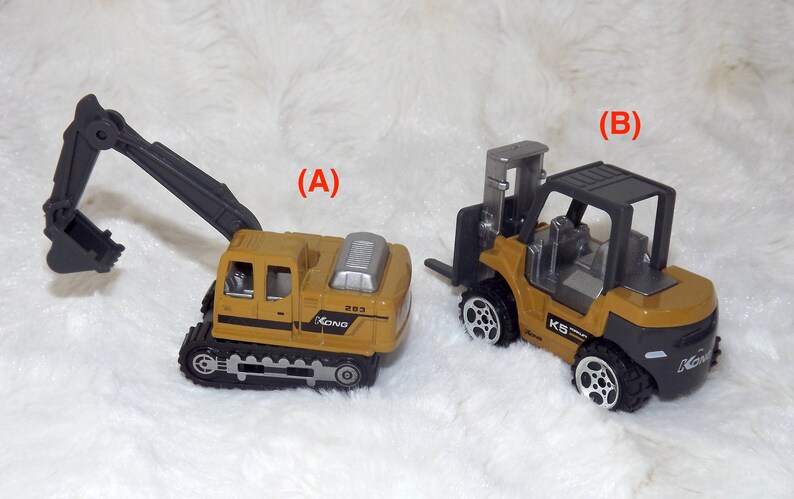 K&ouml;nnte beinhalten: Zwei Spielzeug-Baumaschinen, ein gelber Bagger mit einem schwarzen Arm und ein gelber Gabelstapler mit einem schwarzen Rahmen. Beide Fahrzeuge haben schwarze R&auml;der und sind mit dem Wort "Kong" beschriftet.
