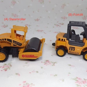 May include: Two toy construction vehicles, a yellow steamroller with a black roller and a yellow forklift with a black cab. The steamroller has the text "RR604" on the side and the forklift has the text "Classic 53 Hercules" on the side.