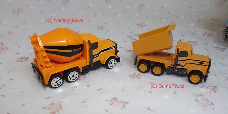 May include: Two toy construction trucks, a yellow cement mixer truck with black stripes and a yellow dump truck with a raised bed. Both trucks have black wheels.