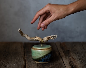 Small ceramic lidded storage jar with wooden handle