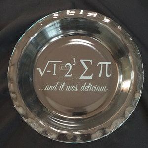 May include: A clear glass pie plate with the text "√-1²³Σπ...and it was delicious" etched into the bottom.