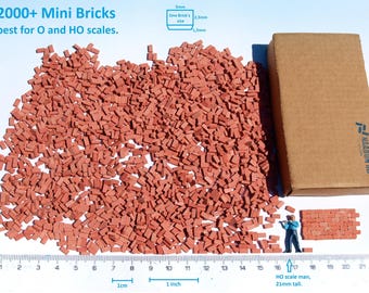 May include: A large quantity of small, red brick-shaped pieces, ideal for model building. The bricks are spread out on a white surface with a ruler for scale. The image also shows a brown cardboard box with the text "HAARON 88" printed on the side. The text "2000+ Mini Bricks best for O and HO scales." is visible at the top of the image.