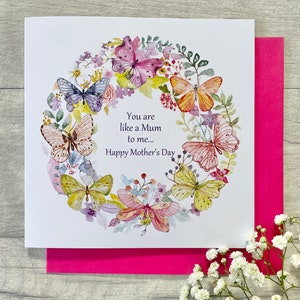 May include: A white card with a watercolor illustration of a wreath of butterflies and flowers. The text on the card reads "You are like a Mum to me... Happy Mother's Day."