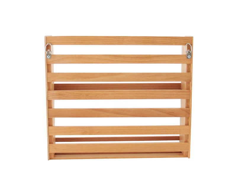 May include: A wooden wall-mounted shelf with five horizontal shelves and metal hooks on the sides. The shelf is made of natural wood and has a light brown finish.