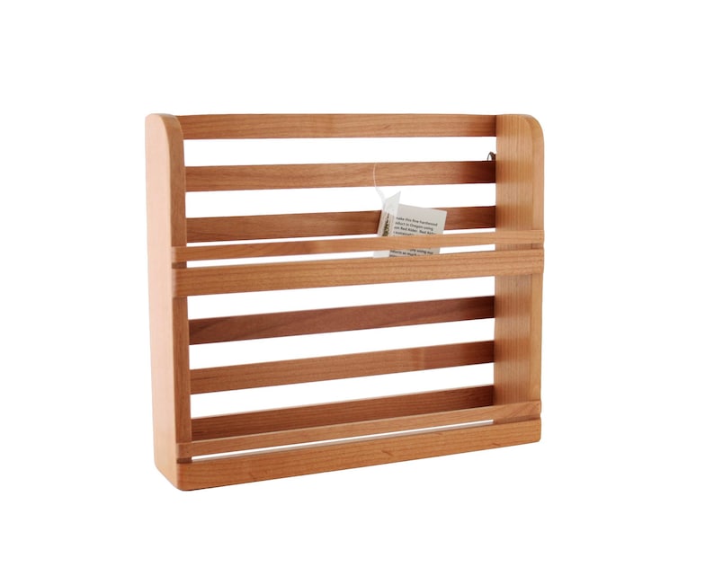 May include: A wooden spice rack with five shelves. The rack is made of light brown wood and has a natural finish.