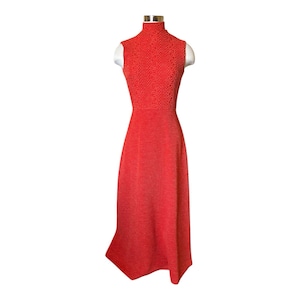 May include: A sleeveless maxi dress with a high neck and a crocheted bodice. The dress is a bright orange color.
