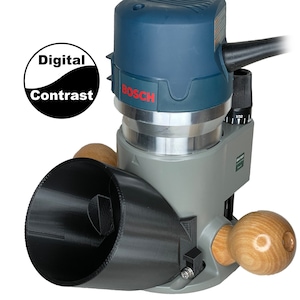 May include: A blue and gray Bosch router with a black dust collection shroud and wooden handles. The router is attached to a black plastic base with a clear plastic cover. The router has a speed control dial and a depth adjustment knob.