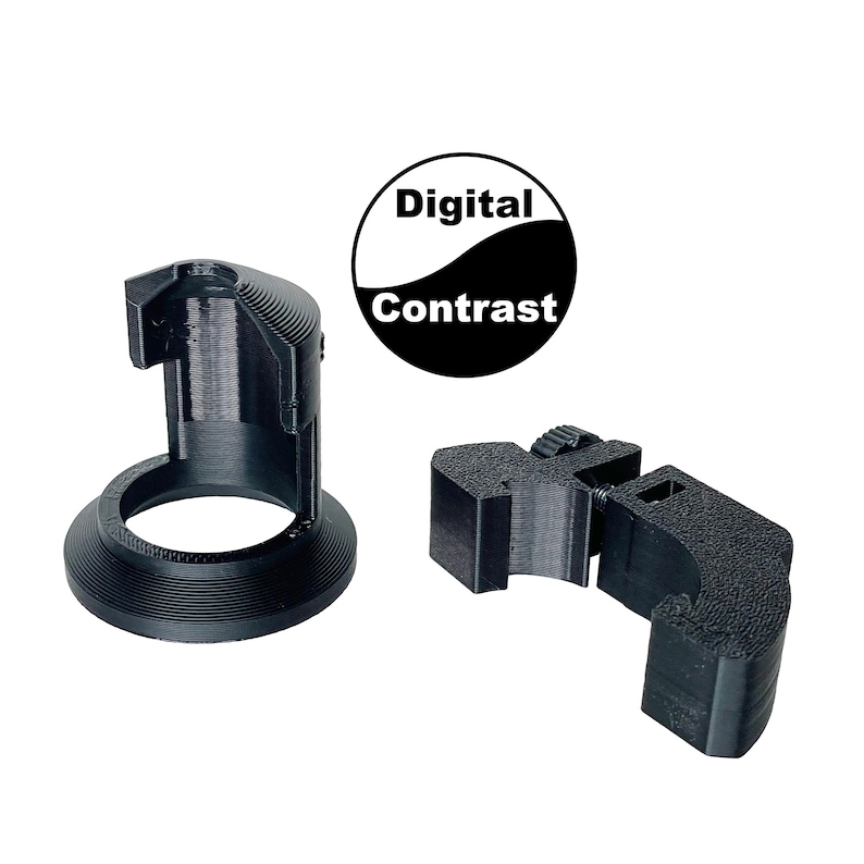 K&ouml;nnte beinhalten: Zwei schwarze Kunststoff-Objektivadapter f&uuml;r Kameras. Einer ist ein runder Adapter mit einem Gewindeloch und einem Sockel. Der andere ist ein Klemmadapter mit einem Gewindeloch. Der Text "Digital Contrast" ist auf einem schwarz-wei&szlig;en Kreis gedruckt.
