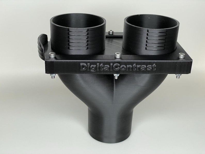 May include: A black 3D-printed object with two cylindrical openings and a Y-shaped base. The object has the text "DigitalContrast" on the top surface and is secured with multiple screws. The design appears to be a custom-made component.