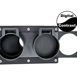 May include: A black 3D-printed camera accessory with two circular holders and a circular opening. The accessory has a rectangular base with mounting holes and the text "Digital Contrast" in a black and white circle.