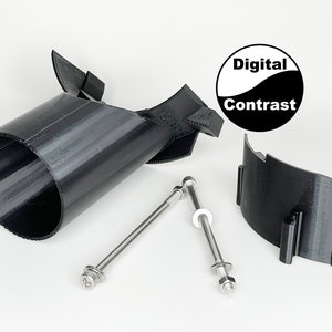 May include: A black 3D printed object with a cylindrical shape and a curved top. The object is attached to a black 3D printed base with two silver screws. The object is labeled "Digital Contrast".