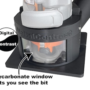 Pu&ograve; includere: Base per router Digital Contrast nera con finestra in policarbonato trasparente. Il testo "Digital Contrast" &egrave; stampato sul lato. &Egrave; visibile anche il testo "Polycarbonate window lets you see the bit".