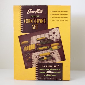 May include: A yellow box with a picture of corn on the cob on the front. The box is labeled "Serv-Rite Deluxe Corn Service Set" and says "18 Piece Set".