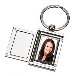 May include: Silver metal photo keychain with a hinged frame that opens to reveal a space for a photo. The keychain has a silver metal ring.