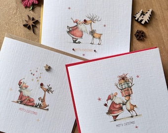 May include: Three square white textured greeting cards featuring illustrations of Santa Claus and a reindeer. The cards show scenes of the pair interacting, decorated with small red gems and stars. Text on the cards reads Merry Christmas.