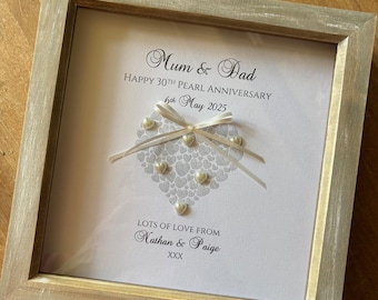 May include: A framed white card with a pearl heart design and the text "Mum & Dad Happy 30th Pearl Anniversary 6th May 2025 Lots of Love From Nathan & Paige XXX"