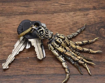 May include: A brass octopus keychain with intricate details and a decorative ring. The keychain is attached to a set of keys.