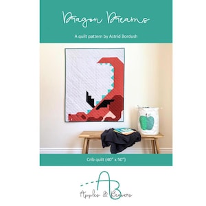 May include: A crib quilt with a red and teal dragon design, measuring 40 inches by 50 inches. The quilt is displayed on a wall, with the text "Dragon Dreams" and "A quilt pattern by Astrid Bordush" above it. A bench and a storage basket are in front of the quilt.