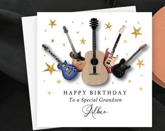 Puede incluir: Tarjeta de felicitación blanca con temática musical. Presenta ilustraciones de cinco guitarras de varios colores, rodeadas de estrellas doradas. El texto dice "HAPPY BIRTHDAY To a Special Grandson Albie."