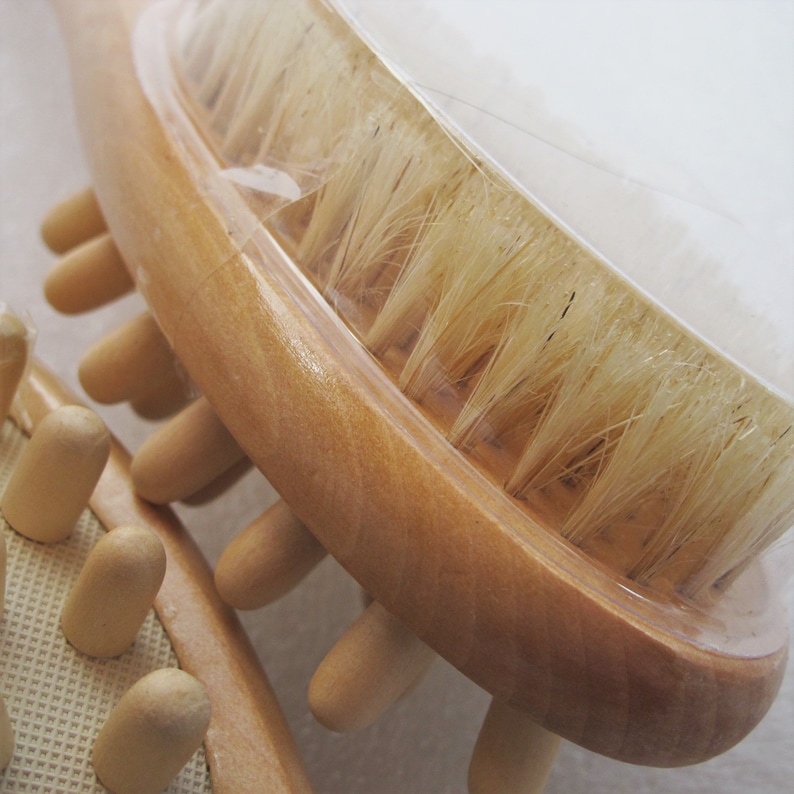 Op de afbeelding: Een houten lichaamsborstel met natuurlijke borstels en een handvat met een rij houten knoppen. De borstel is ontworpen voor droog borstelen.