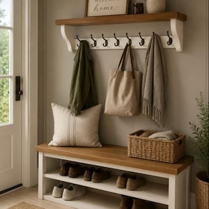 May include: A white and wood entryway bench with two shelves holding six pairs of shoes, topped with a matching wall-mounted coat rack featuring eight black hooks. A sign reading WELCOME home sits on the shelf with a small potted plant.