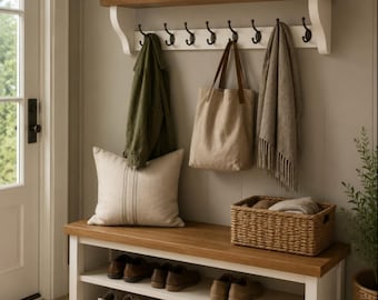 May include: A white and wood entryway bench with two shelves holding six pairs of shoes, topped with a matching wall-mounted coat rack featuring eight black hooks. A sign reading WELCOME home sits on the shelf with a small potted plant.