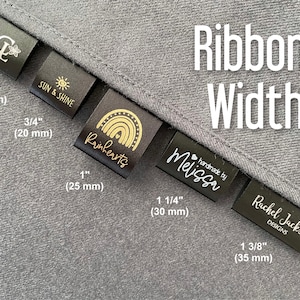 K&ouml;nnte beinhalten: Schwarze Stoff-Etiketten mit goldener Schrift und Designs, die verschiedene Bandbreiten in Zoll und Millimetern zeigen. Die Etiketten enthalten den Text "Sun & Shine", "Rainhearts", "Handmade by Melissa" und "Rachel Jackson Designs".