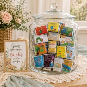 May include: A large clear glass jar filled with miniature candy bars wrapped in labels featuring classic children's book covers. Next to the jar is a wooden sign with the text: Guess how many books are in the jar, featuring illustrations of a teddy bear and a rabbit.