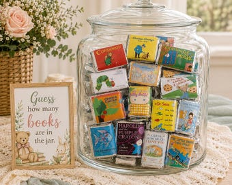 May include: A large clear glass jar filled with miniature candy bars wrapped in labels featuring classic children's book covers. Next to the jar is a wooden sign with the text: Guess how many books are in the jar, featuring illustrations of a teddy bear and a rabbit.