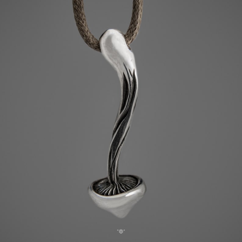 May include: A silver pendant necklace featuring a detailed mushroom design with a textured stem and a smooth cap.
