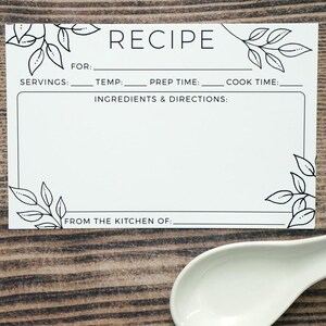 May include: A white recipe card with black text and leaf illustrations. The card includes sections for servings, temperature, prep time, cook time, ingredients, and directions. The text "RECIPE" is at the top, and "FROM THE KITCHEN OF:" is at the bottom.