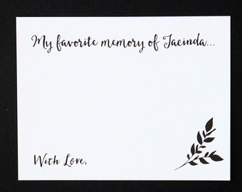 May include: A white card with black calligraphy that reads "My favorite memory of Jacinda..." and "With Love,". A black leaf design is in the bottom right corner. The card is on a black background.