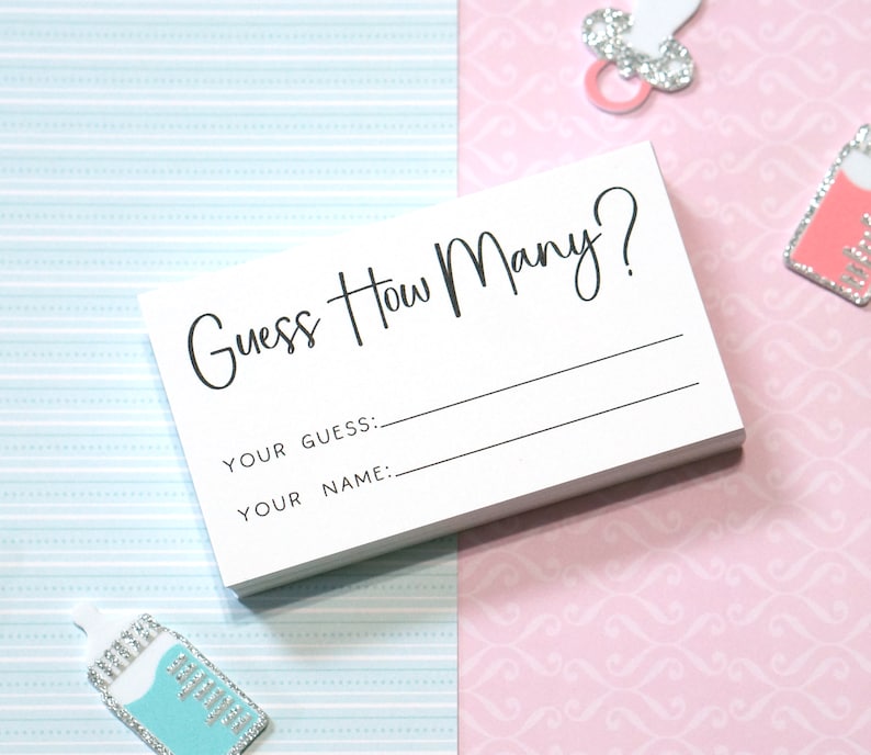 Op de afbeelding: Een stapel witte kaarten met de tekst "Guess How Many?" in zwart schrift. Daaronder staan lijnen voor "Your Guess:" en "Your Name:" op elke kaart. De achtergrond is een mix van lichtblauw en roze papier met patronen, met baby-thema versieringen.