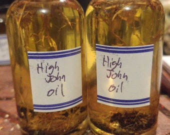 Peut inclure: Deux petites bouteilles en verre avec des couvercles noirs remplies d'un liquide jaune et étiquetées "High John Oil".