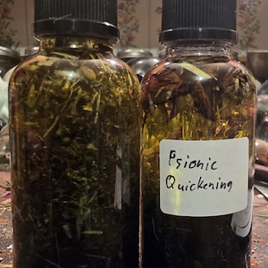 May include: Two glass bottles filled with a dark liquid and herbs. The bottle on the right has a white label that reads "Psionic Quickening".