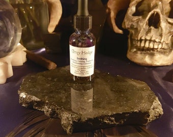 May include: A small glass bottle with a dropper top, filled with a purple liquid. The bottle is labelled "Grey Hedge Soothing" and lists ingredients including "Lavender, Calming, Eucalyptus, Relationship Cleansing, and Herbs, Resin and Essential Oils.  Conc."