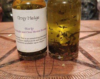 May include: Two small glass bottles with black lids filled with a clear liquid and herbs. The bottles are labelled "Grey Hedge" and "Clarity Insight and Clear Mental Blockage".