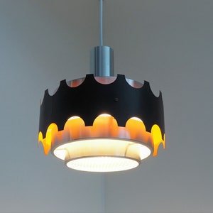 May include: A black and gold pendant light fixture with a scalloped edge and a white inner shade.