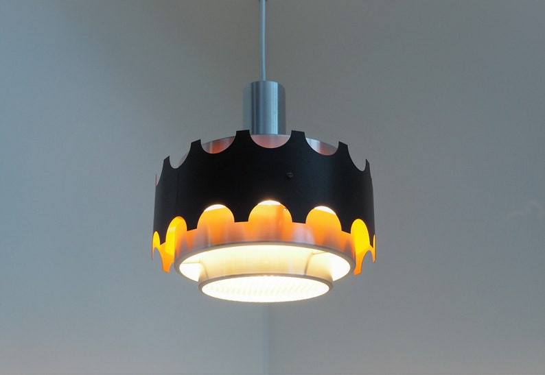 May include: A black and gold pendant light fixture with a scalloped edge and a white inner shade.