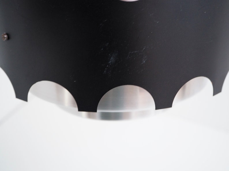 May include: Black pendant light fixture with a scalloped edge and a silver interior.