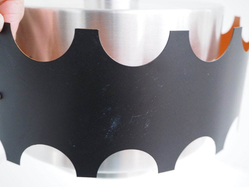 May include: A black metal pendant light fixture with a scalloped edge and a silver interior.