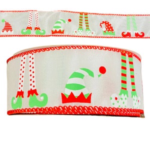 May include: A roll of white ribbon with a repeating pattern of elf hats and legs in red and green. The ribbon's edges are trimmed with a red, scalloped border, perfect for holiday crafts and gift wrapping.