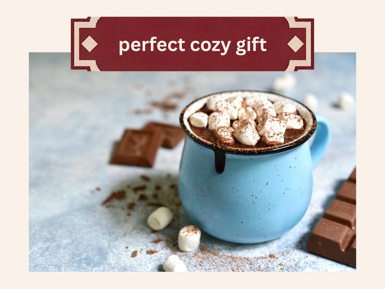Może przedstawiać: Jasnoniebieski, nakrapiany kubek ceramiczny wypełniony gorącą czekoladą z białymi piankami marshmallow, z ciemnoczerwonym banerem u g&oacute;ry z białym napisem perfect cozy gift, w towarzystwie rozrzuconych kawałk&oacute;w czekolady i pianek marshmallow.