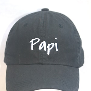 May include: A black baseball cap with a white embroidered word "Papi" on the front.
