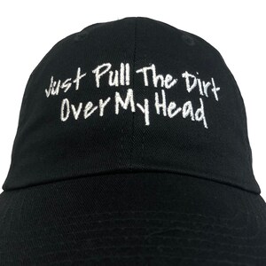 May include: Black baseball cap with white embroidered text that reads "Just Pull The Dirt Over My Head".
