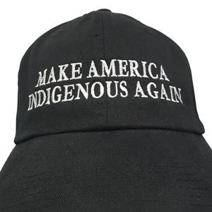 May include: Black baseball cap with white embroidered text that reads "Make America Indigenous Again".