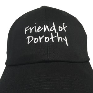May include: A black baseball cap with white embroidery that reads "Friend of Dorothy".
