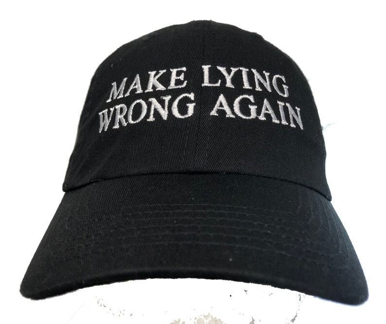 Puede incluir: Gorra de b&eacute;isbol negra con el texto "MAKE LYING WRONG AGAIN" bordado en blanco.